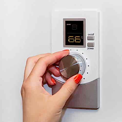 gas-boiler-a-woman-regulates-the-temperature-with-a-temperature-controller-setting-the-room-temperature-blaby