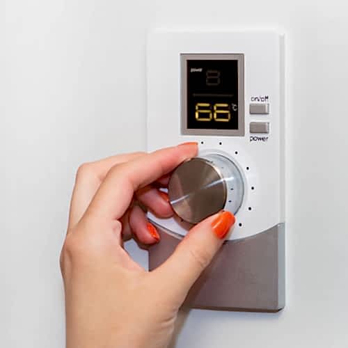 gas-boiler-a-woman-regulates-the-temperature-with-a-temperature-controller-setting-the-room-temperature-fleckney