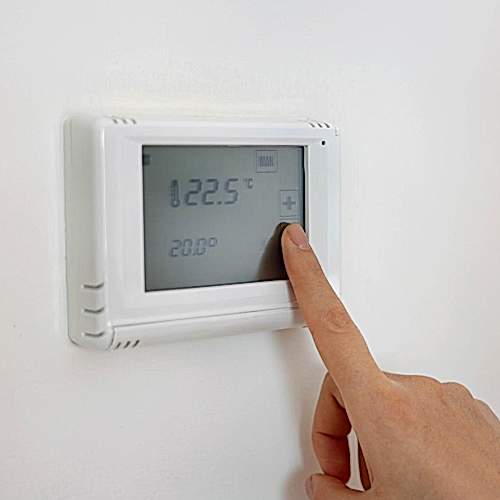 lowering-the-temperature-for-energy-saving-human-hand-adjusting-digital-central-heating-thermostat-at-home-cosby